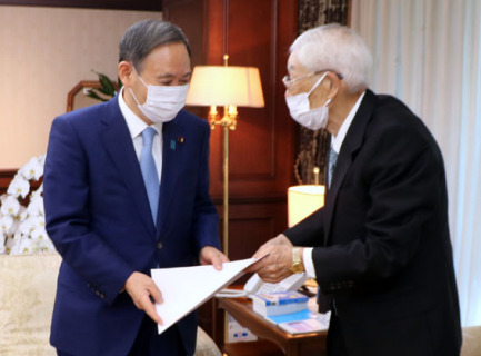 菅首相（左）に要望書を手渡す新田会長＝29日午前9時5分ごろ、自民党本部